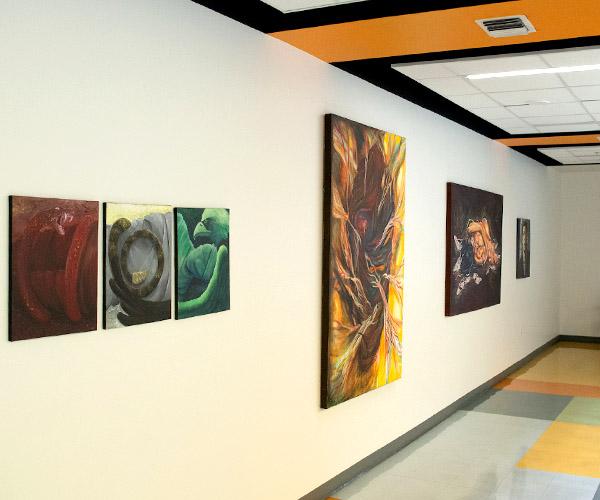 Paintings hanging by the entrance to a university art gallery
